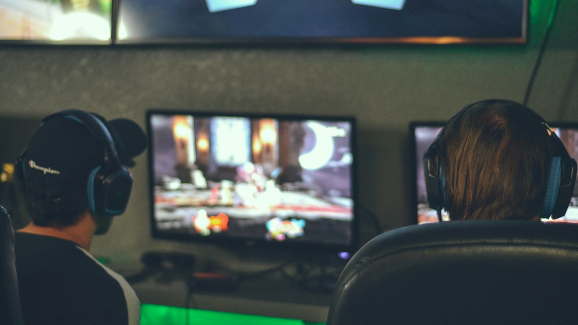 NeonQuestRaiders players competing at a gaming station